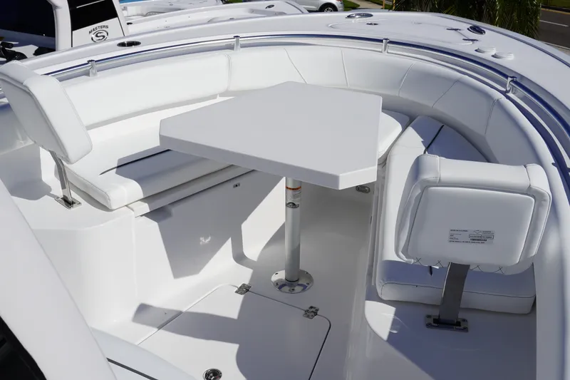 Slide: The Image of 2027 Sportsman Open 232 Center Console boat with white seating and table setup. - 18