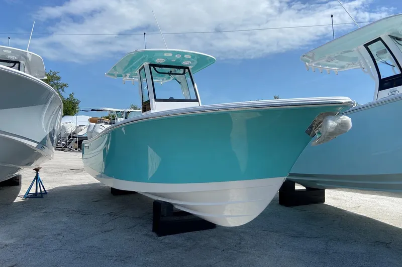 The Image of 2027 Sportsman Open 232 Center Console boat in vibrant turquoise, displayed outdoors. - 0