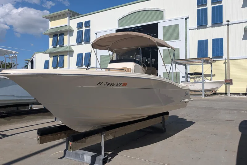 Slide: The Image of 2019 Scout 215 XSF boat docked outdoors under clear blue sky. - 4