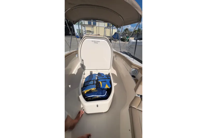 Slide: The Image of 2019 Scout 215 XSF boat with open storage compartment containing life jackets. - 34