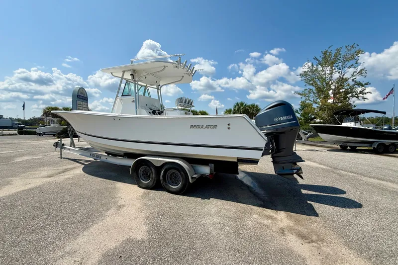 Slide: The Image of 2007 Regulator 29 Forward Seating boat on trailer, parked outdoors under blue sky. - 2