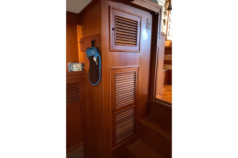 Slide: The Image of Wooden interior of 1985 CHB 42 boat with louvered doors and hanging items. - 58