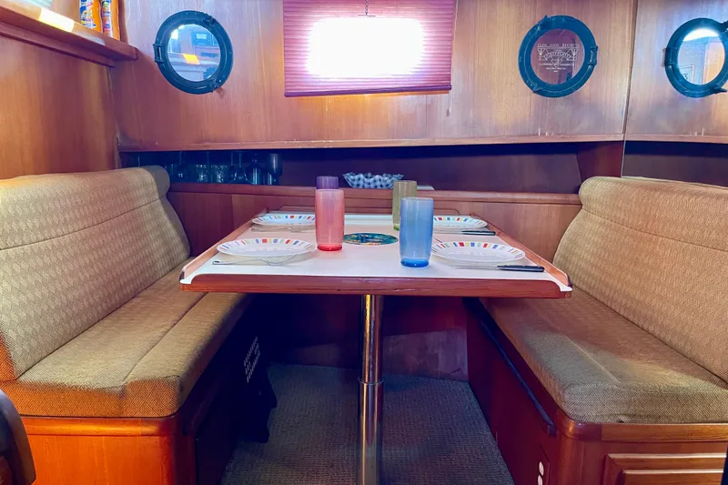 Slide: The Image of Cozy dining area inside a 1985 CHB 42 boat, featuring a table set for four. - 45