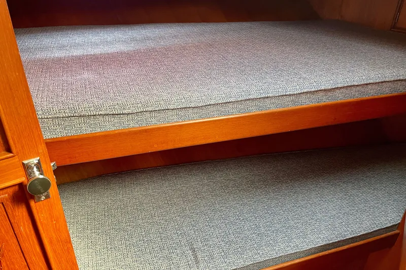 Slide: The Image of Wooden bunk beds with gray cushions in a 1985 CHB 42 boat interior. - 48