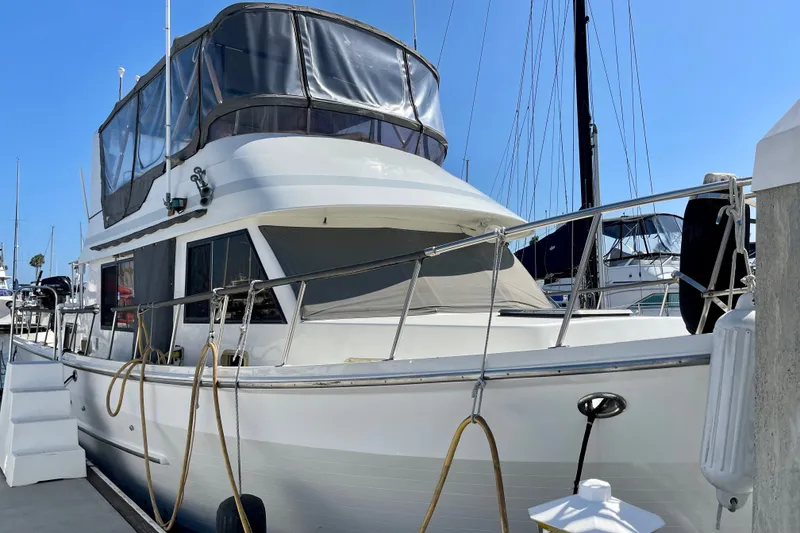 Slide: The Image of 1985 CHB 42 yacht docked at marina, featuring upper deck enclosure. - 1