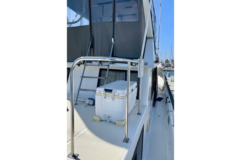 Slide: The Image of 1985 CHB 42 yacht deck with ladder and cooler, docked at marina. - 11