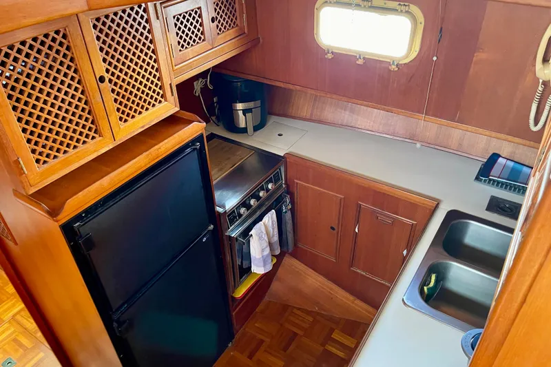 Slide: The Image of Compact kitchen in a 1985 CHB 42 boat with wooden cabinetry and modern appliances. - 38