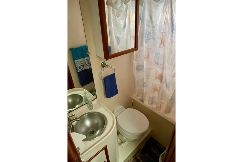 Slide: The Image of Compact bathroom in a 1985 CHB 42 boat with sink, toilet, and shower curtain. - 53