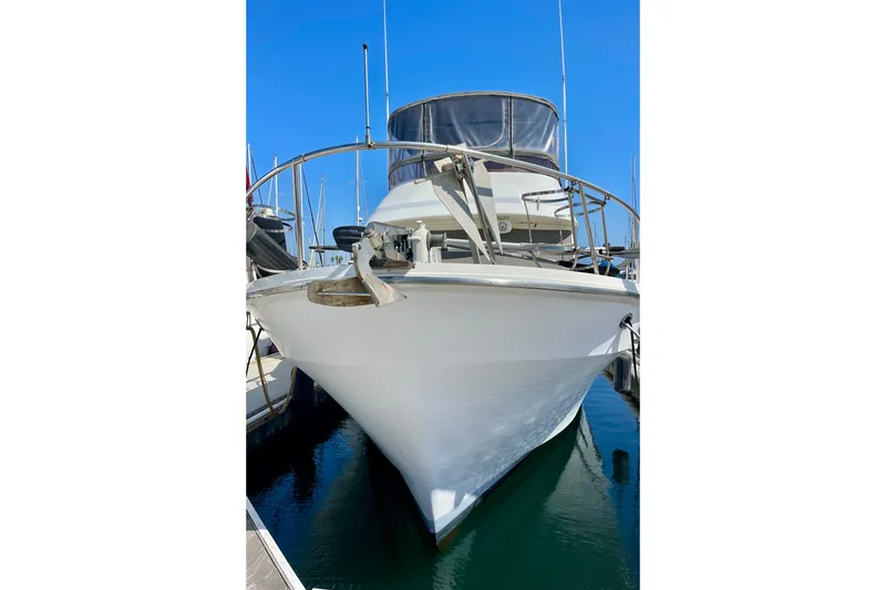 Slide: The Image of 1985 CHB 42 yacht docked in marina, front view under clear blue sky. - 2