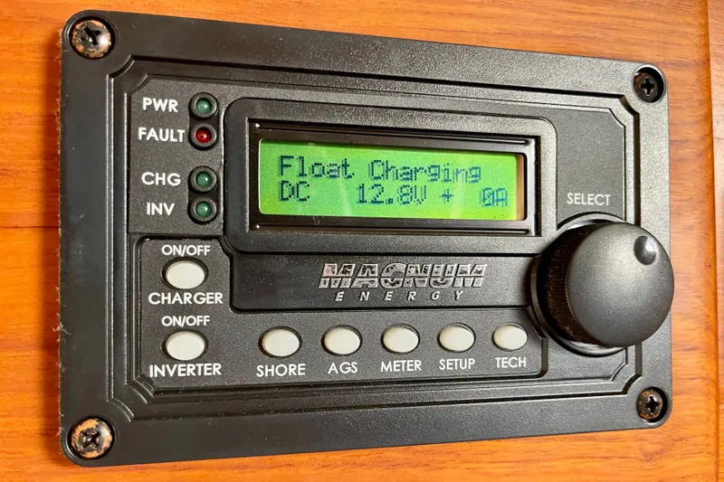 Slide: The Image of Magnum Energy control panel displaying float charging at 12.8V, installed on a 1985 CHB 42. - 31