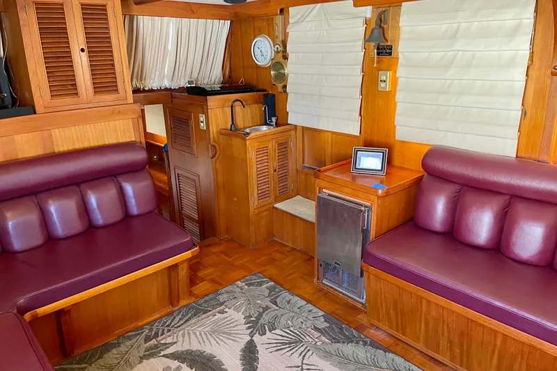 Slide: The Image of Interior of a 1985 CHB 42 boat with wood paneling and maroon seating. - 26