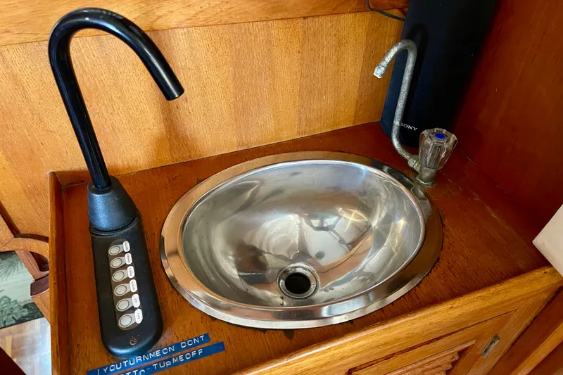 Slide: The Image of 1985 CHB 42 boat sink with faucet and control panel on wooden countertop. - 27