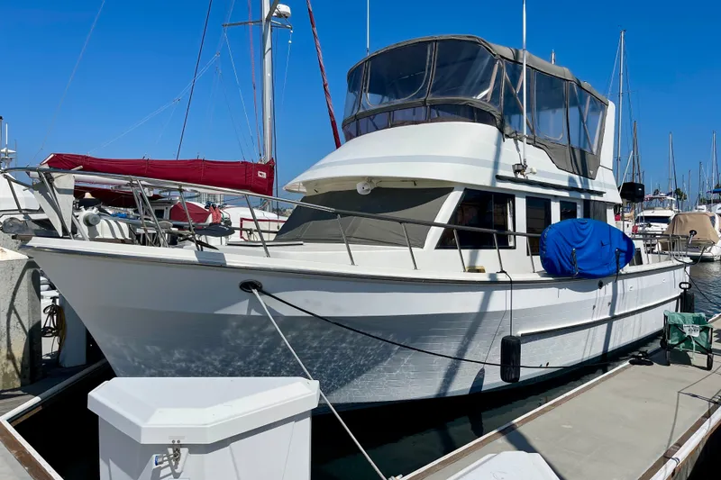 Slide: The Image of 1985 CHB 42 yacht docked at marina under clear blue sky. - 0