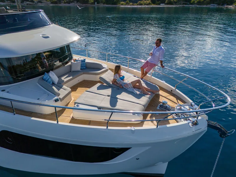 Slide: The Image of Couple relaxing on 2026 Absolute Navetta Co Ownership yacht, enjoying serene waters. - 14