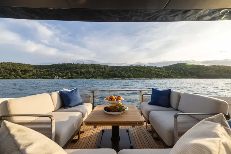 Slide: The Image of Luxurious 2026 Absolute Navetta yacht deck with comfortable seating, scenic water view, and fruit centerpiece. - 19