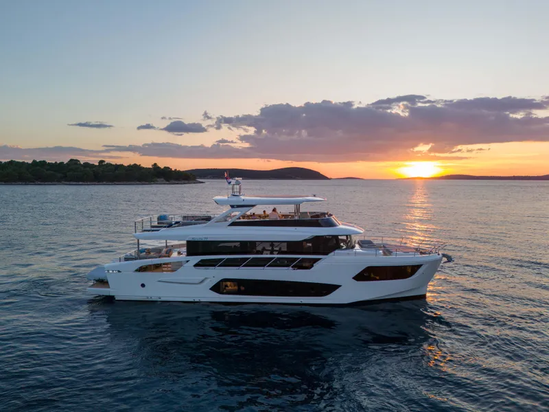 Slide: The Image of 2026 Absolute Navetta Co Ownership yacht at sunset on the ocean. - 2