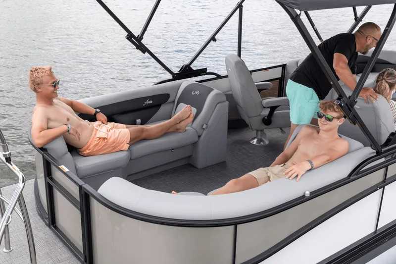 Slide: The Image of Two people relax on a Barletta Aria 22 QC pontoon boat on the water. - 1