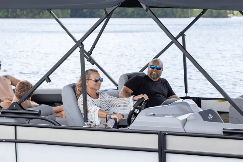 Slide: The Image of A woman steers a Barletta Aria 22 QC boat, while a man sits beside her. - 3