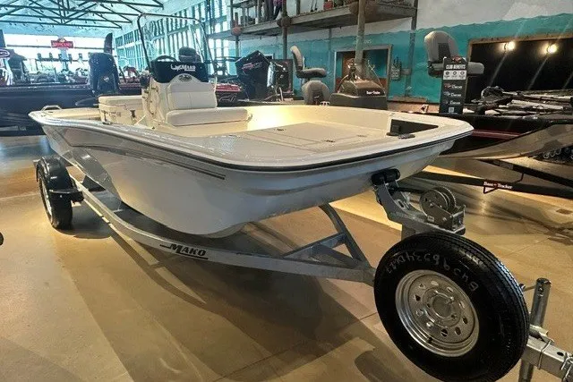 Slide: The Image of 2027 Mako Pro Skiff 15 CC boat on display in a showroom. - 1