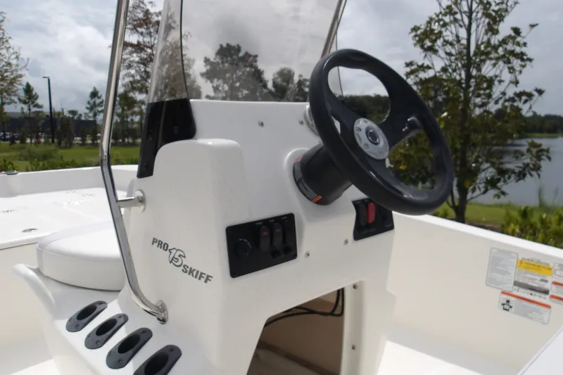Slide: The Image of 2027 Mako Pro Skiff 15 CC boat console with steering wheel and control panel. - 11