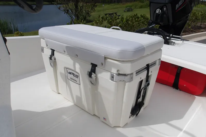 Slide: The Image of 2027 Mako Pro Skiff 15 CC boat with cushioned cooler seat on deck. - 10