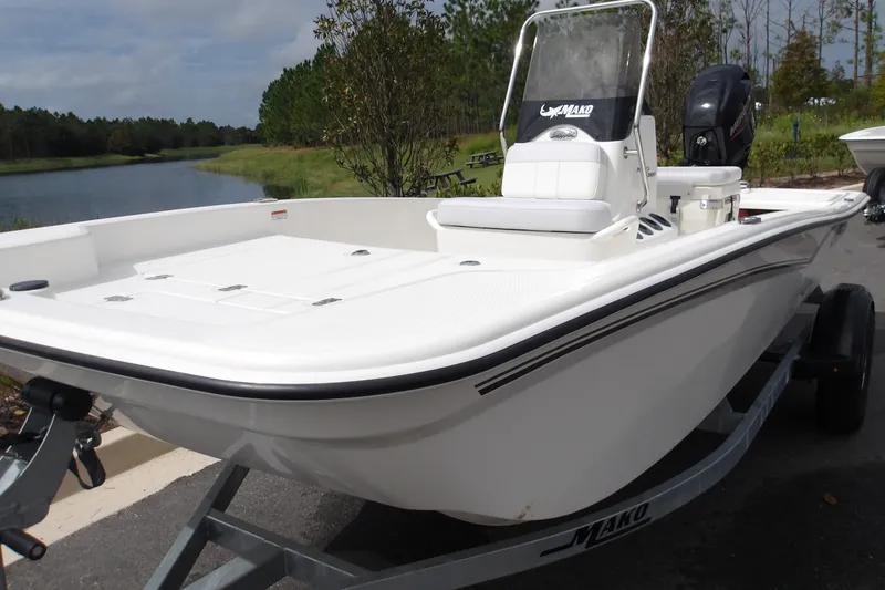 Slide: The Image of 2027 Mako Pro Skiff 15 CC boat on trailer by a scenic lake. - 8