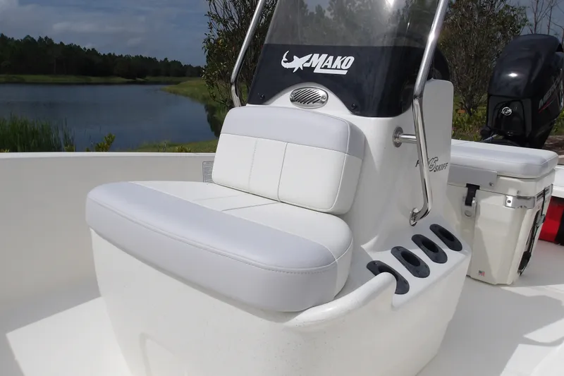 Slide: The Image of 2027 Mako Pro Skiff 15 CC boat with white seating and console by a lake. - 12