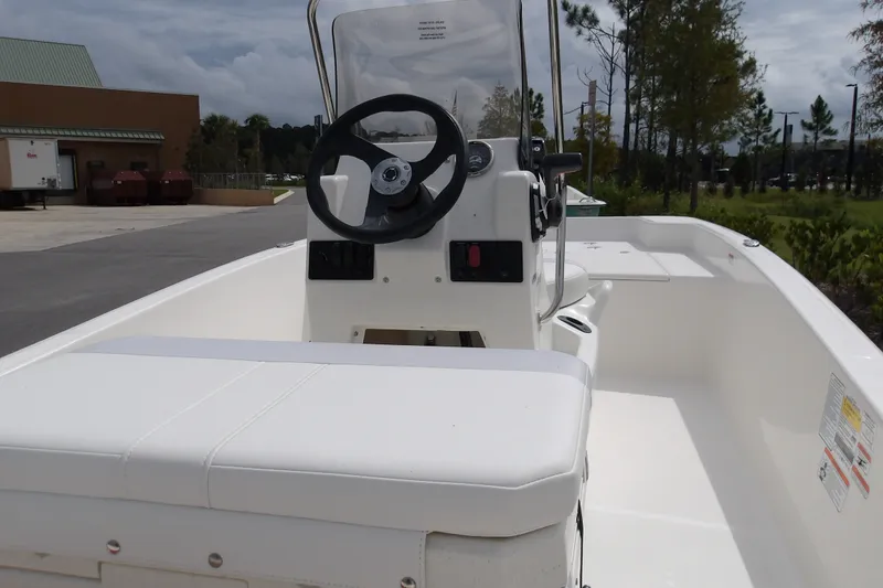 Slide: The Image of 2027 Mako Pro Skiff 15 CC boat interior with steering console and seating. - 6