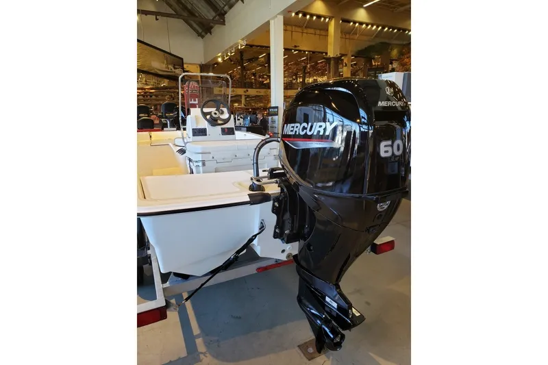 Slide: The Image of 2027 Mako Pro Skiff 15 CC with Mercury 60 outboard motor in showroom. - 3