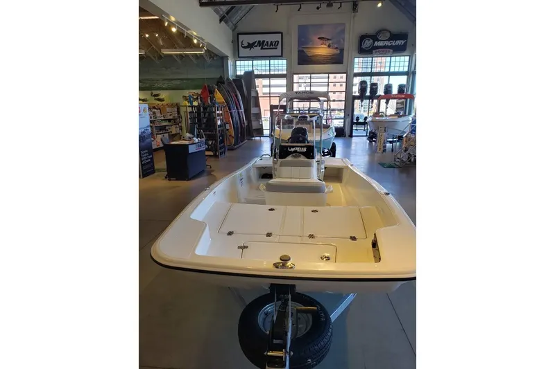 Slide: The Image of 2027 Mako Pro Skiff 15 CC displayed in a showroom with boating equipment. - 5