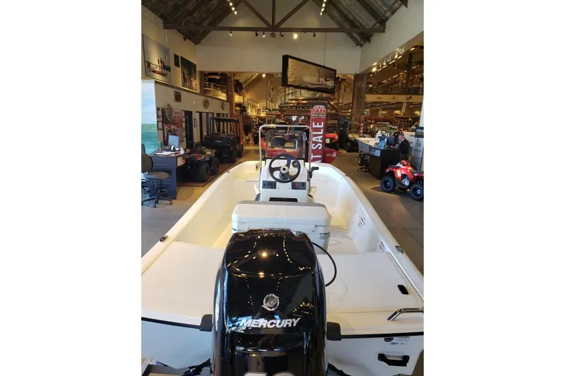 Slide: The Image of 2027 Mako Pro Skiff 15 CC boat displayed in showroom with Mercury engine. - 4