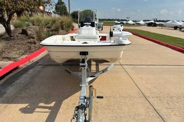 Slide: The Image of 2027 Mako Pro Skiff 15 CC boat on trailer, parked outdoors on a sunny day. - 2
