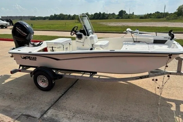Slide: The Image of 2027 Mako Pro Skiff 15 CC boat on trailer, parked outdoors. - 1
