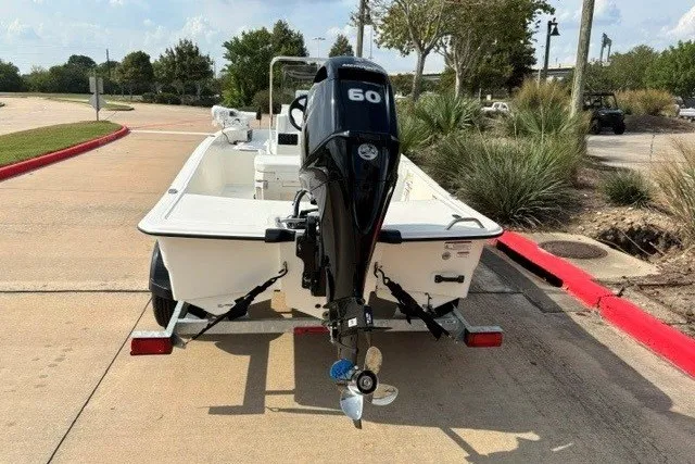 Slide: The Image of 2027 Mako Pro Skiff 15 CC boat on trailer, featuring a 60 HP outboard motor. - 10