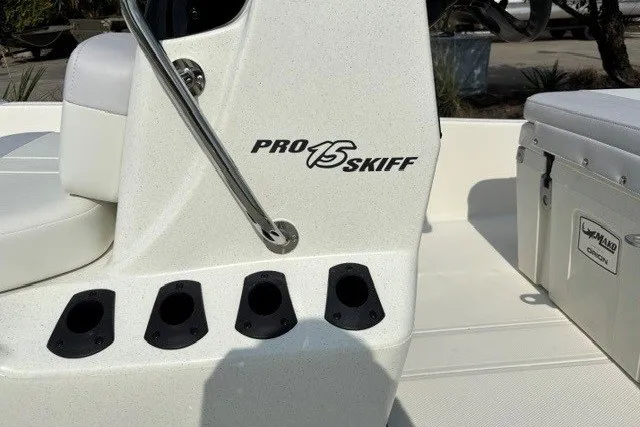 Slide: The Image of 2027 Mako Pro Skiff 15 CC boat interior with rod holders and cooler. - 8