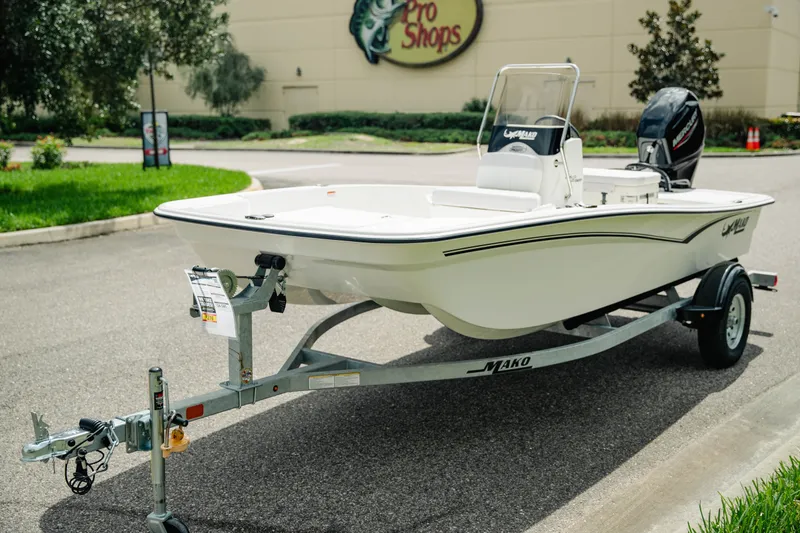 Slide: The Image of 2027 Mako Pro Skiff 15 CC boat on trailer outside Pro Shops store. - 4