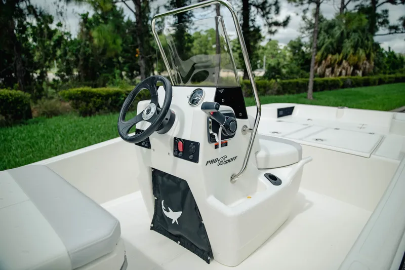 Slide: The Image of 2027 Mako Pro Skiff 15 CC boat with steering console, outdoors. - 10