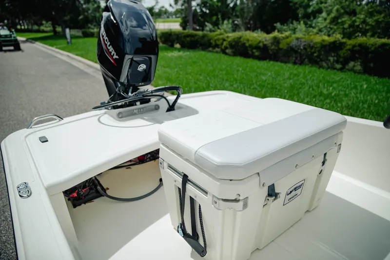 Slide: The Image of 2027 Mako Pro Skiff 15 CC boat with Mercury engine and cooler on deck. - 9