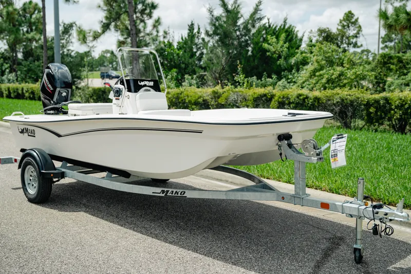 Slide: The Image of 2027 Mako Pro Skiff 15 CC boat on trailer, parked on a sunny day. - 2