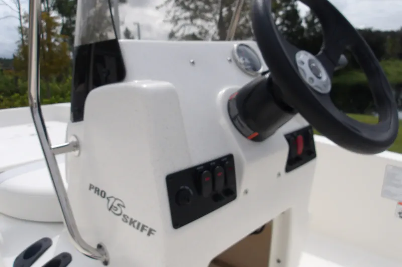 Slide: The Image of 2027 Mako Pro Skiff 15 CC boat console with steering wheel and controls. - 11