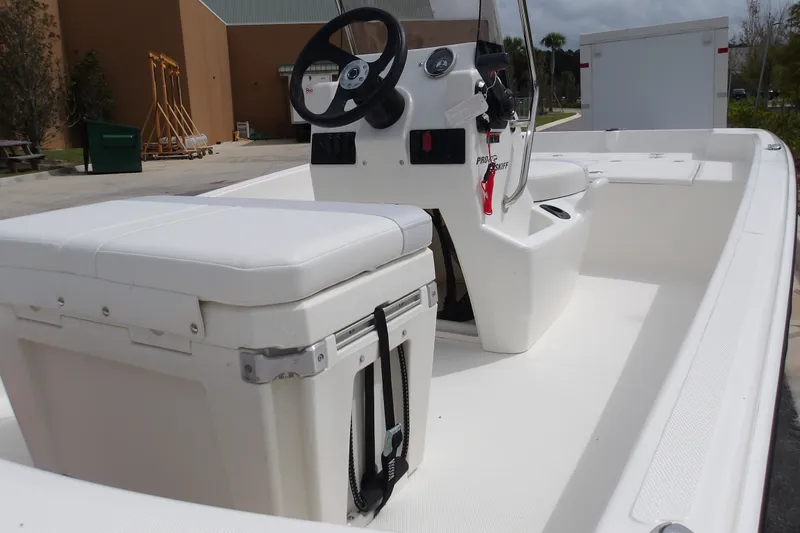Slide: The Image of 2027 Mako Pro Skiff 15 CC boat interior with steering console and seating. - 5