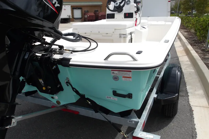 The Image of 2027 Mako Pro Skiff 15 CC boat on trailer, featuring outboard motor and sleek design. - 0
