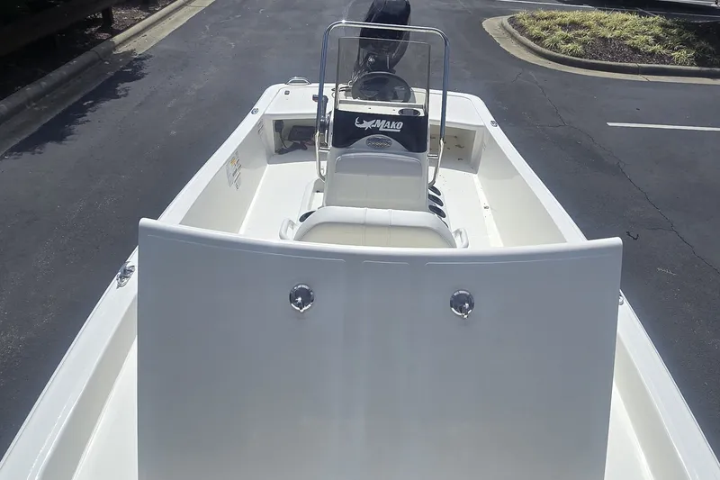 Slide: The Image of 2027 Mako Pro Skiff 15 CC boat, white interior, parked on asphalt. - 1