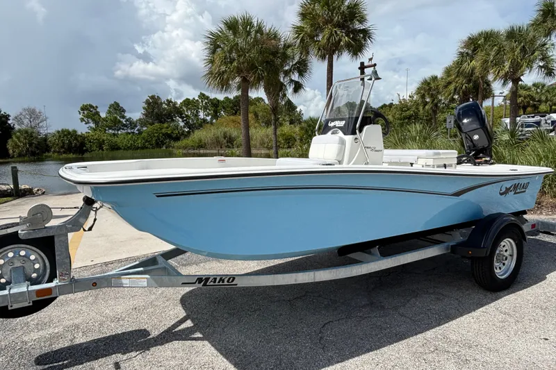 The Image of 2027 Mako Pro Skiff 15 CC boat on trailer, parked near palm trees. - 0