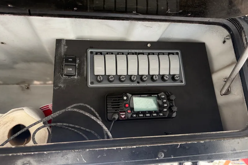 Slide: The Image of Control panel of a 1999 Blue Fin 260 Profish boat with switches and radio. - 18