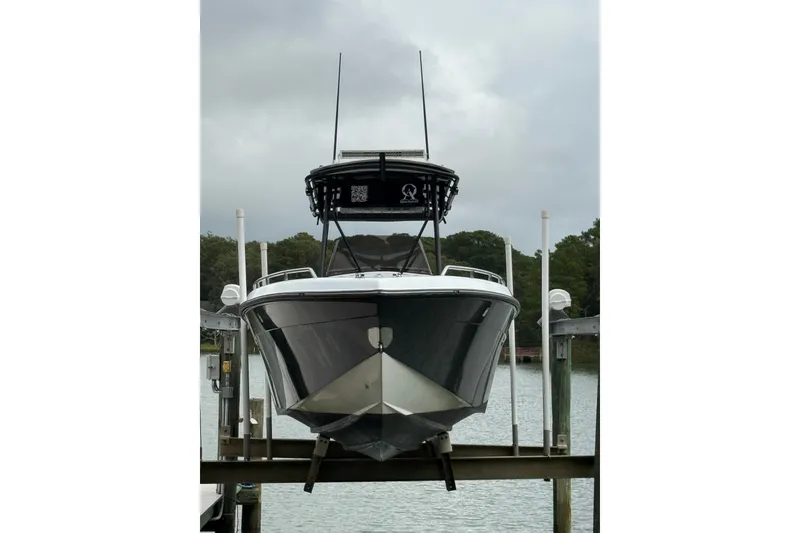 Slide: The Image of 1999 Blue Fin 260 Profish boat docked on a lift, front view. - 6