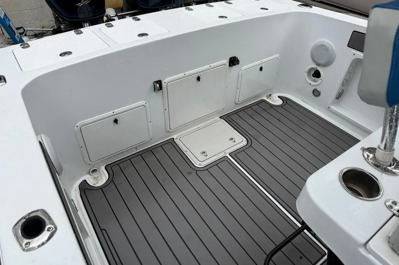Slide: The Image of 1999 Blue Fin 260 Profish boat deck with storage compartments and non-slip flooring. - 24