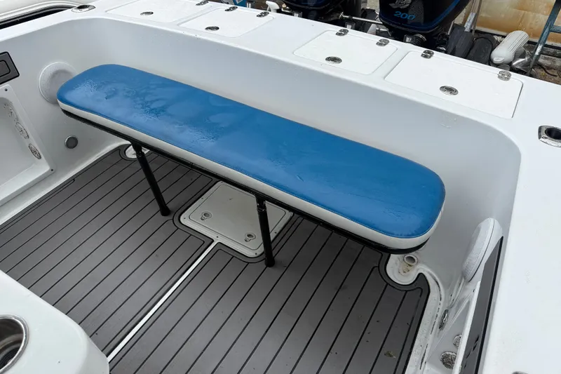 Slide: The Image of Blue Fin 260 Profish 1999 boat interior with blue cushioned bench and gray flooring. - 21