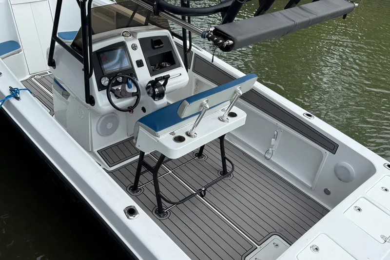 Slide: The Image of 1999 Blue Fin 260 Profish boat interior with steering console and seating, docked on water. - 9