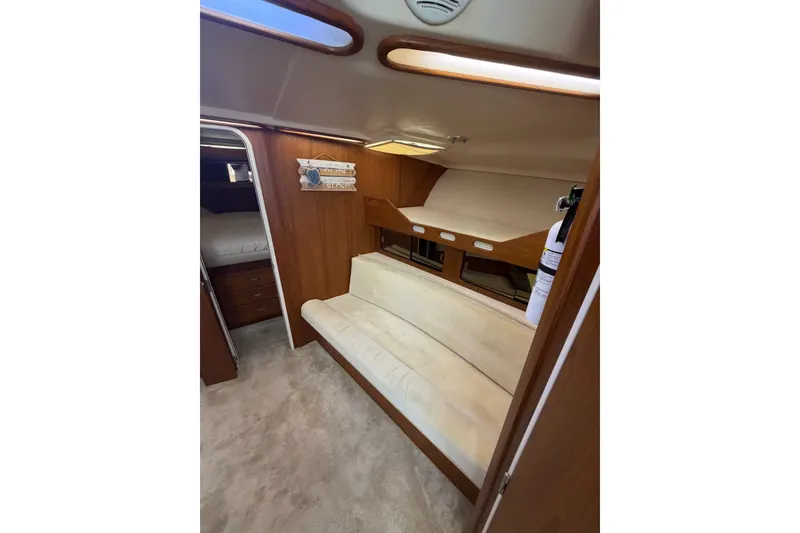 Slide: The Image of 1998 Luhrs 40 Open cabin interior with beige seating and wooden accents. - 14
